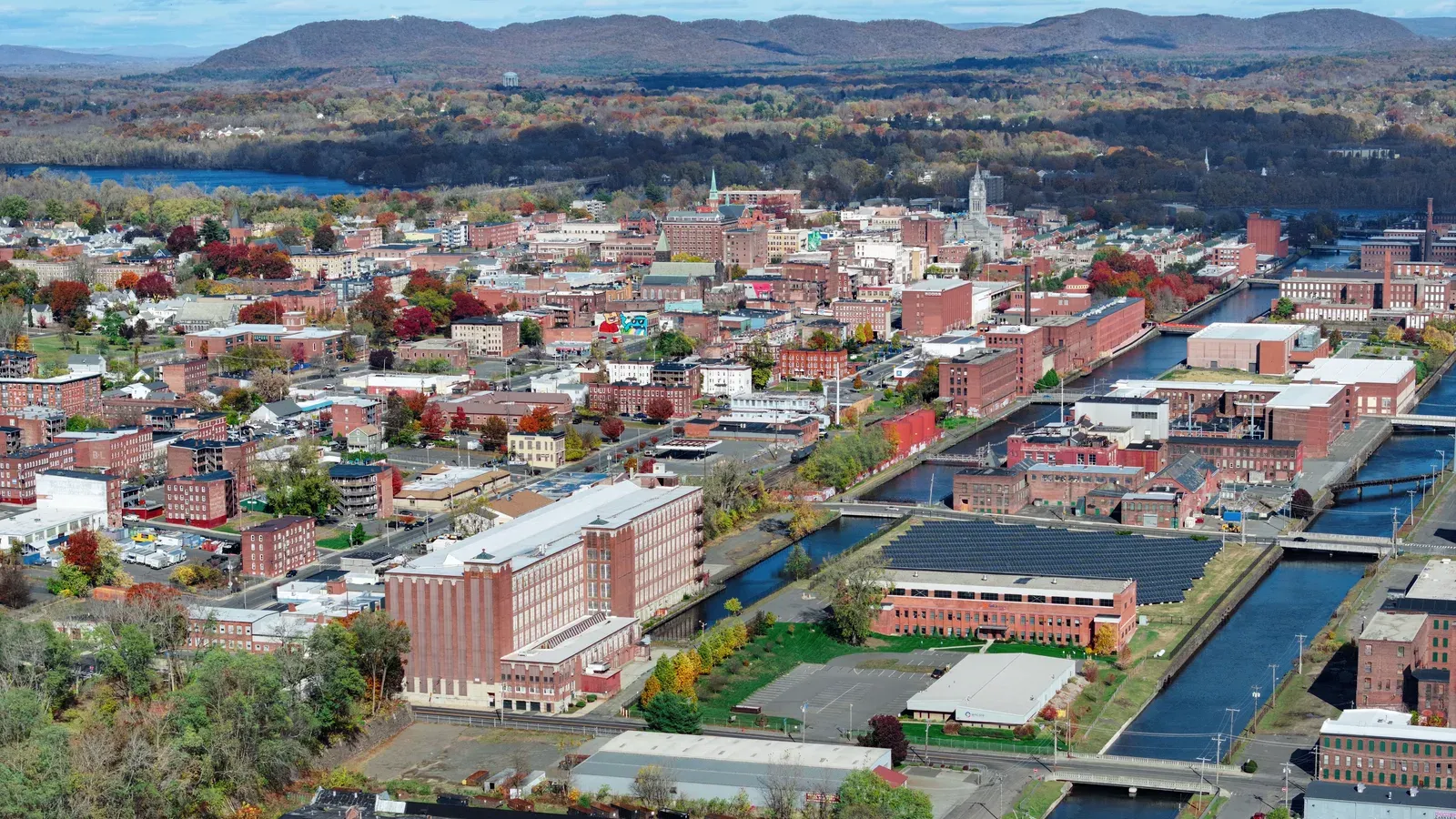 Aerial view of downtown mills along the power canals with hills beyond, Holyoke, Massachusetts