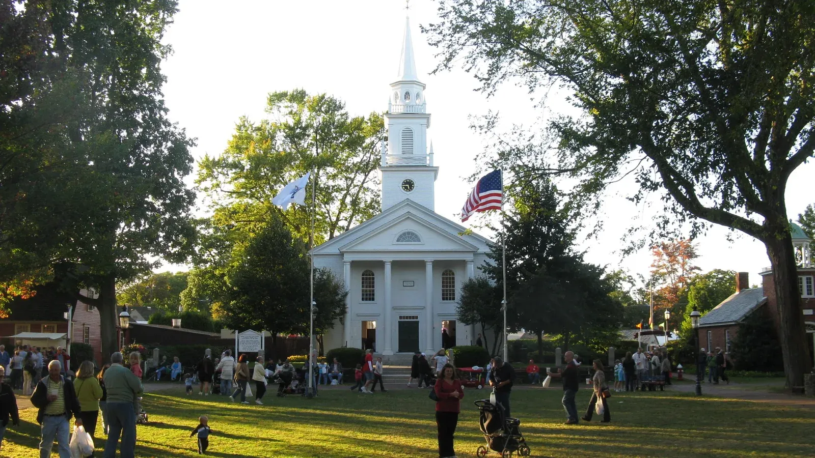 Town common with a tiered fountain, flagpole, and downtown storefronts, West Springfield, Massachusetts